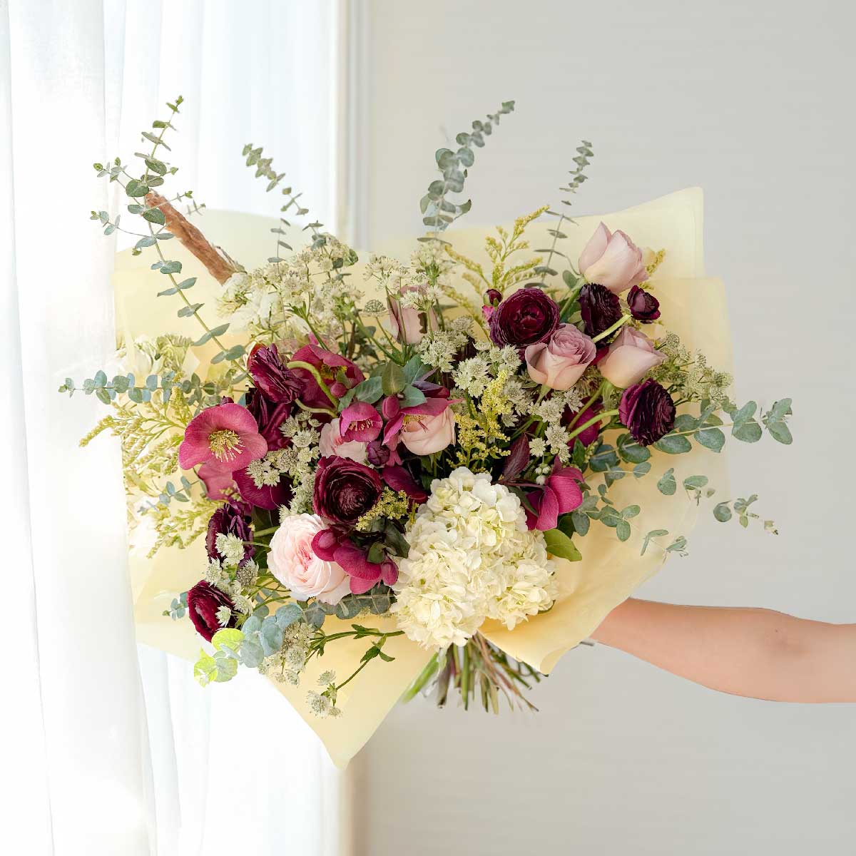 Holding a Deep_moody Burgundy and pink colours bouquet