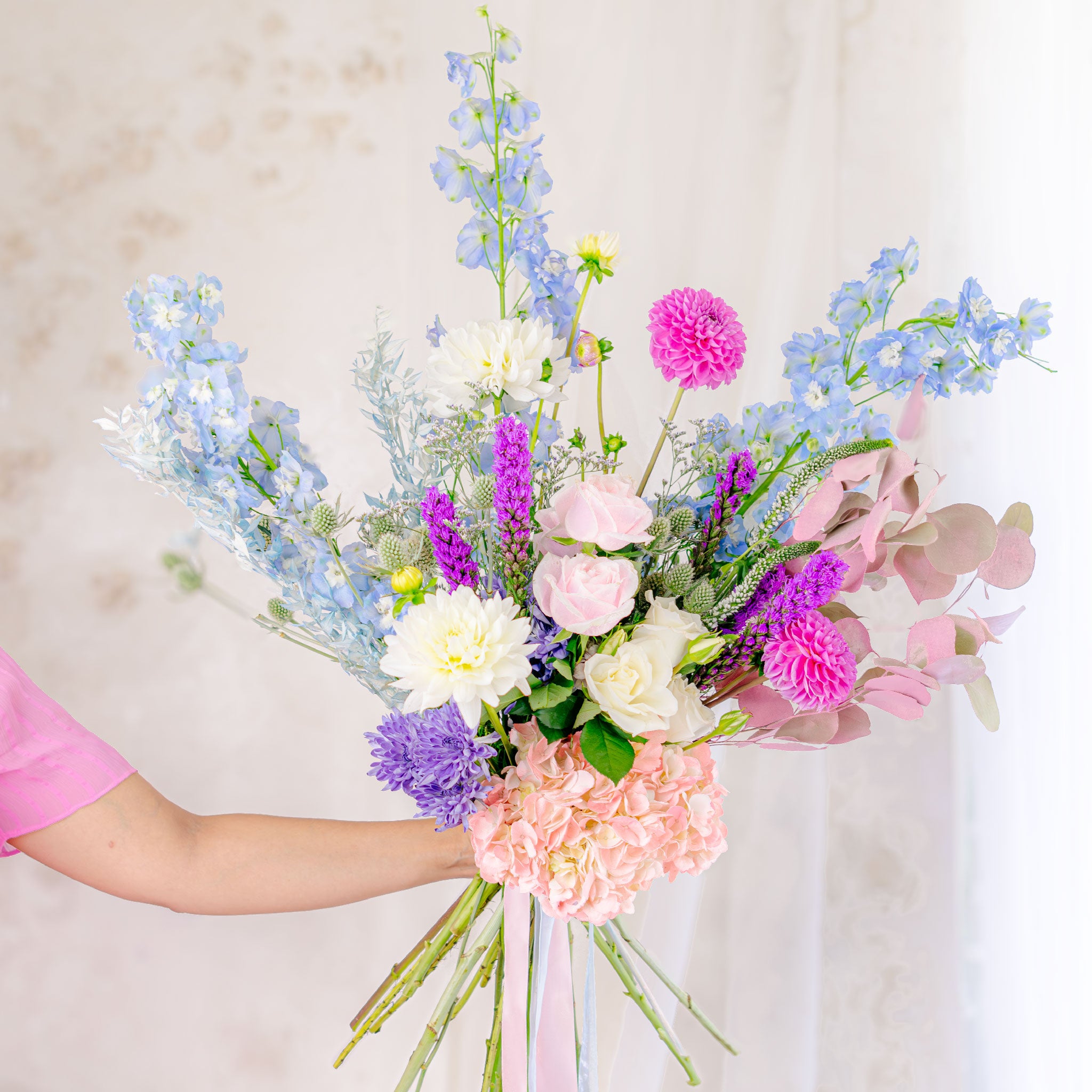 Holding Pastel themed designers choice bouquet